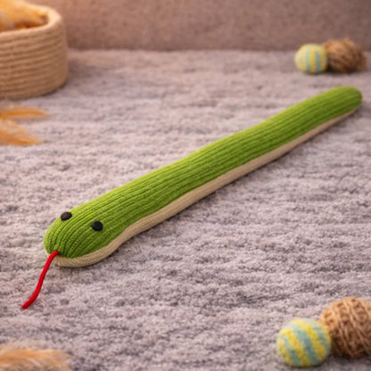 Green ribbed plush snake cat toy with black eyes and red tongue on a gray rug.