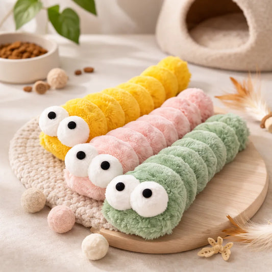 Three plush catnip kicker caterpillar toys in yellow, pink, and green with large white eyes.