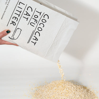 Cococat Tofu Cat Litter being poured from a white bag onto a white surface.