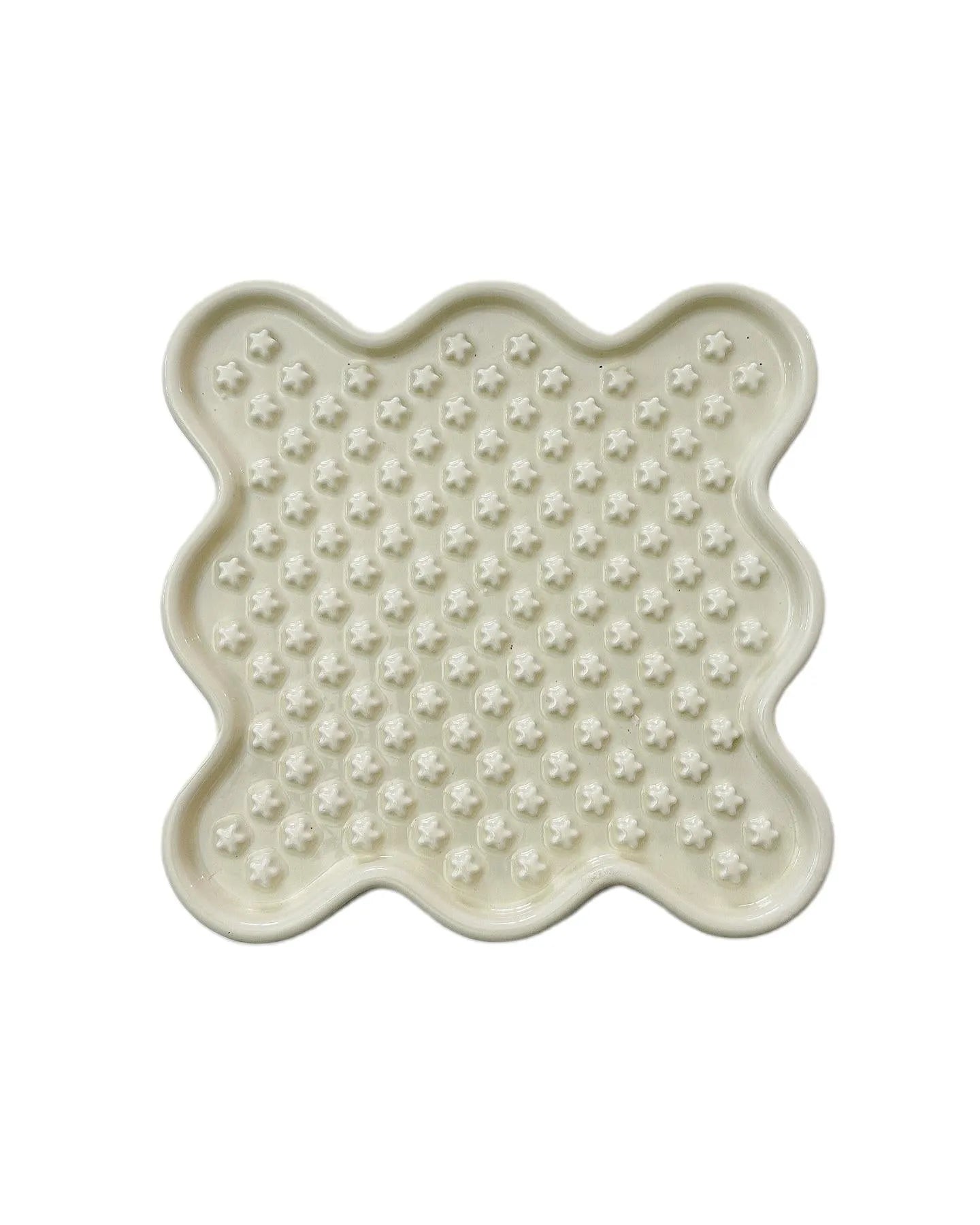 White ceramic Fussy Cat slow feeder bowl with star-shaped ridges, designed like a lick mat.