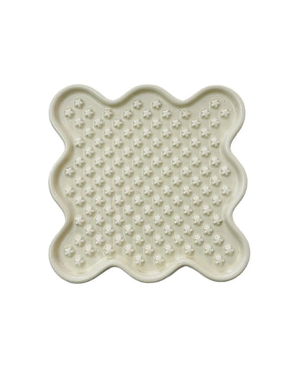 White ceramic Fussy Cat slow feeder bowl with star-shaped ridges, designed like a lick mat.
