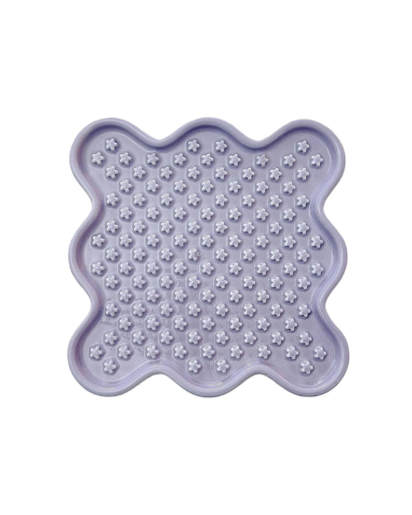 Light purple ceramic Fussy Cat slow feeder with flower-shaped divots for healthy eating.