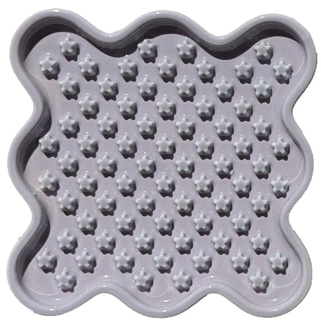 Lavender ceramic Fussy Cat slow feeder with a wavy edge and star-shaped food compartments.