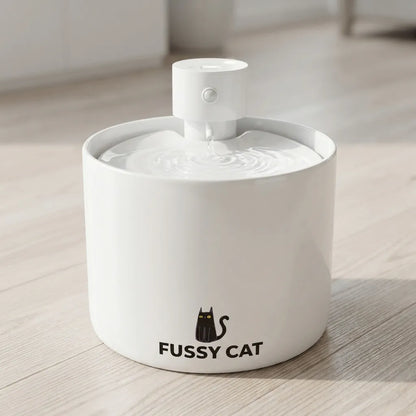 White ceramic Fussy Cat water fountain with a black cat logo, featuring a central pump and flowing water.