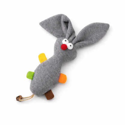 Grey plush rabbit cat toy with long ears, red nose, white eyes, colorful fabric tags, and a braided tail.