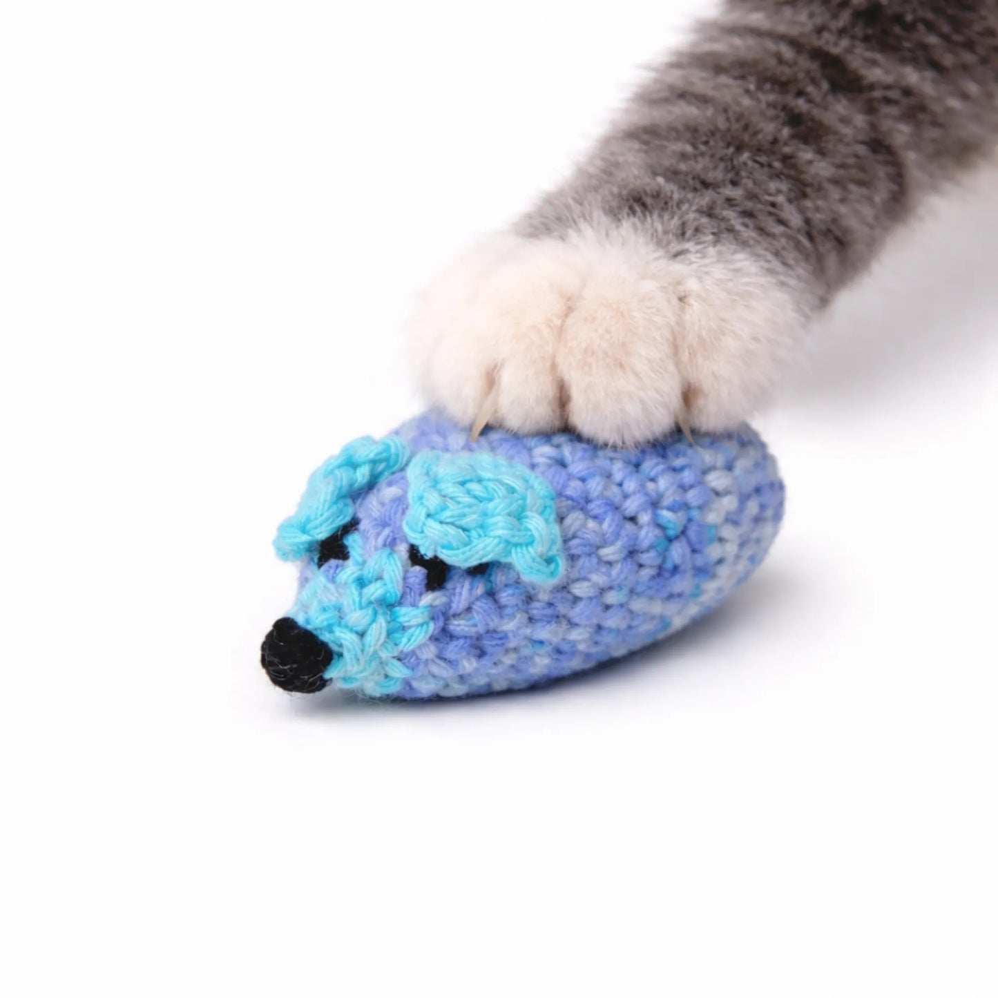 Cat paw on a handmade blue crocheted wool catnip mouse toy.