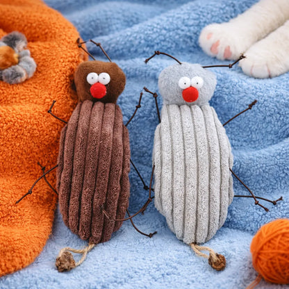 Two plush cockroach cat toys, one brown and one grey, with red noses and wire legs, on blue and orange towels.