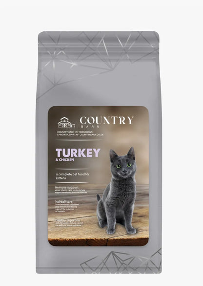 Gray kitten food bag with "Country Barn Turkey & Chicken" label and a gray cat on a wooden surface.