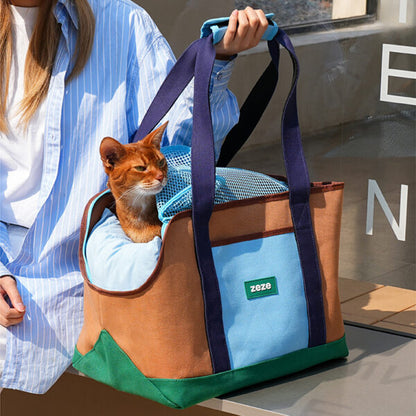 ZEZE brown and turquoise canvas pet carrier with an orange cat looking out, held by a person.