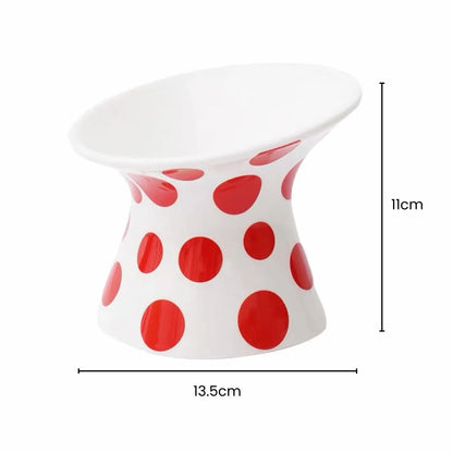White ceramic pet bowl with red polka dots, 12° tilted, raised design, 13.5cm wide, 11cm high.